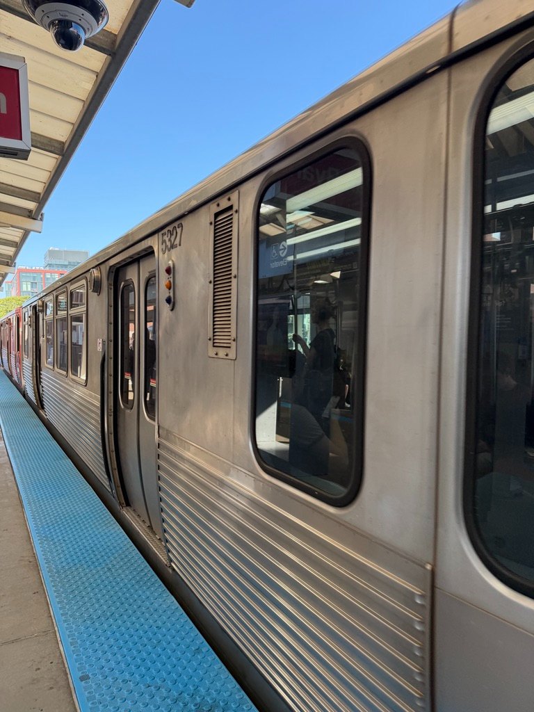A CTA train pulled up to a platform on a clear day in Chicago